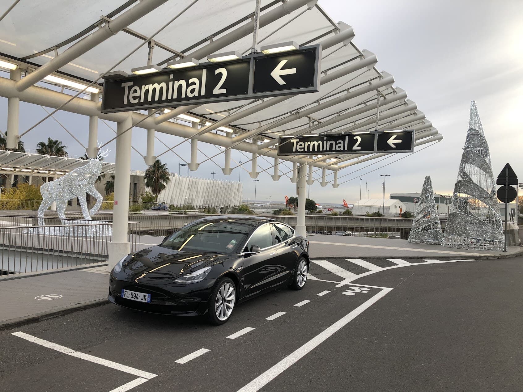 Tesla Model 3 noire de Find Your Driver devant le Terminal 2 de l’aéroport de Nice.